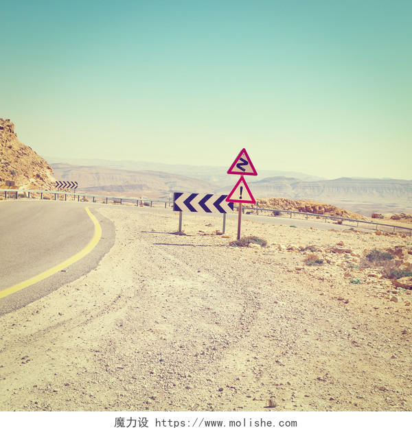沙漠中弯曲的公路与警示牌